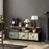 A TV stand with drawers and decorative elements is shown in a room setting. Podgląd zdjęcia produktu