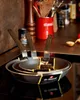 A set of De Buyer frying pans stacked on a stovetop, with kitchen utensils and spices in the background. Produktbild-Vorschau