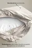 A close-up view of a fitted sheet, showing its layered construction and material details. Podgląd zdjęcia produktu