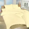 A neatly made bed with yellow bedding in a room. Podgląd zdjęcia produktu