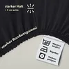 A close-up of a black fabric product with text and care symbols. Produktbild-Vorschau