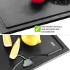 A close-up of a black cutting board with lemons and juice. Podgląd zdjęcia produktu
