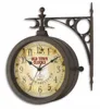 A double-sided antique-style wall clock mounted on a decorative metal bracket. Anteprima dell’immagine prodotto
