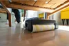 A robot vacuum cleaner is cleaning under a wooden chair. Anteprima dell’immagine prodotto