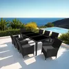 An outdoor dining set with a black rattan table and chairs is placed on a patio overlooking the ocean. Voir les images du produit