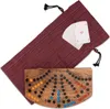 A wooden Tock game board and a deck of cards are laid out on a white background, partially covered by a red drawstring bag. Náhled obrázku produktu