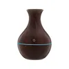 A brown aroma diffuser with a blue light ring and a power button symbol. Produktbild-Vorschau