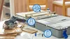 A Dremel cordless circular saw and a Dremel saw table are displayed on a table with some wood pieces. Produktbild-Vorschau