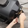 A person is adding wood pellets to a pellet grill. Voir les images du produit
