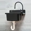 A black sink with a flexible black faucet is mounted on a gray textured wall. White plumbing pipes are visible underneath. Produktbild-Vorschau