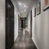 A modern hallway with dark doors, tiled floor, and track lighting. Anteprima dell’immagine prodotto