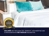 A neatly made bed with white sheets and two decorative pillows. Produktbild-Vorschau