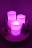 Three LED candles with a color-changing feature are arranged on a wooden base with decorative Christmas trees and a star. Produktbild-Vorschau
