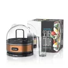A copper and clear egg cooker with a measuring cup and a box for the product are displayed on a white background. Produktbild-Vorschau
