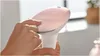 A hand is shown pressing a button on a pink and white hair removal device. Náhled obrázku produktu