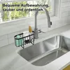 A kitchen sink area with a faucet, a sponge holder, and cleaning supplies. Produktbild-Vorschau