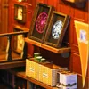 A close-up view of a miniature book nook, possibly a DIY kit, with decorative elements like framed artwork and baskets. Voir les images du produit
