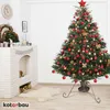 A decorated Christmas tree stands next to a white brick fireplace with a clock on the wall. Náhled obrázku produktu