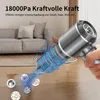 A hand holding a cordless vacuum cleaner, with a graphic showing dust and debris being sucked into it, in a living room setting. Produktbild-Vorschau