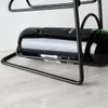 A close-up shot of a black metal wine rack holding a bottle of red wine, placed on a light-colored wooden surface. Anteprima dell’immagine prodotto
