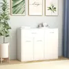 A white sideboard with drawers and cabinets against a light gray wall, with decorative framed pictures above and a potted plant to the side. Anteprima dell’immagine prodotto
