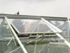 Close-up view of an open greenhouse roof window, showing its aluminum frame and clear glass panels. Produktbild-Vorschau