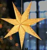 A lit paper star decoration hangs in front of a blurred background with lights. Voir les images du produit
