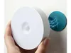 A hand holding a white, round LED night light with a motion sensor. A blue circular graphic with lightning bolts is shown on the wall behind it, suggesting magnetic attachment and wireless functionality. Produktbild-Vorschau