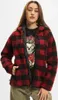 A woman wearing a red and black plaid fleece jacket. Produktbild-Vorschau
