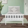 A white wooden bed frame with gray pillows and bedding is shown in a room with light green walls and a wooden floor. Náhľad obrázku produktu