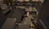 A first-person perspective view of a desert-like environment with buildings and a weapon. Produktbild-Vorschau