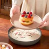 Eine Person wird den Dessertteller mit dem Dessert auf den Tisch stellen. Produktbild-Vorschau