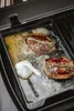 Two steaks are being cooked in a pan with butter, garlic, and rosemary. Produktbild-Vorschau