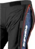Close-up view of the side of black motorcycle pants with a red trim and a blue denim insert with a white logo. Náhled obrázku produktu