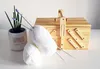 A sewing box with yarn and knitting needles on a white surface. Podgląd zdjęcia produktu