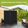 An outdoor patio scene with a black, two-panel room divider set up, featuring outdoor furniture and lush greenery in the background. Anteprima dell’immagine prodotto