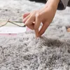 A close-up shot of a hand touching a soft, fluffy rug. Podgląd zdjęcia produktu