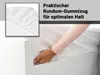 A hand tucking a white fitted sheet onto a mattress, with a close-up inset showing the elastic edge of the sheet. Produktbild-Vorschau