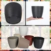 A collage of images showing different colored plant pots, some with saucers, and one being held by a hand. Produktbild-Vorschau