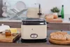 A cream-colored retro toaster sits on a kitchen counter with toast, butter, and honey nearby. Produktbild-Vorschau