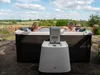 A couple relaxing in a hot tub outdoors with a scenic landscape in the background. Náhľad obrázku produktu