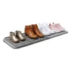 A shoe drying mat with several pairs of shoes on it. Náhled obrázku produktu