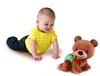 A baby is crawling towards a plush bear toy on a white background. Produktbild-Vorschau