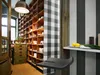 A kitchen pantry with shelves stocked with various items, a checkered pillar, and a striped wall. Produktbild-Vorschau