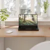 A laptop and external hard drive on a wooden desk in front of a window. Náhľad obrázku produktu