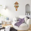A living room scene with a cuckoo clock on the wall and a comfortable armchair. Náhled obrázku produktu
