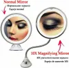 A split image showing a normal mirror and a 10x magnifying mirror, both reflecting a woman's eye makeup. The magnifying mirror is shown with a flexible gooseneck and suction cup base. Podgląd zdjęcia produktu