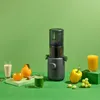 A juicer is displayed with various fruits and vegetables, suggesting its use for making fresh juices. Produktbild-Vorschau