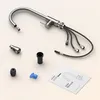 A disassembled kitchen faucet and its components are laid out on a light beige background, along with the user manual. Podgląd zdjęcia produktu