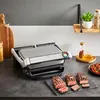 A kitchen counter scene featuring a Tefal Optigrill+ Elektrogrill with grilled steaks. Voir les images du produit